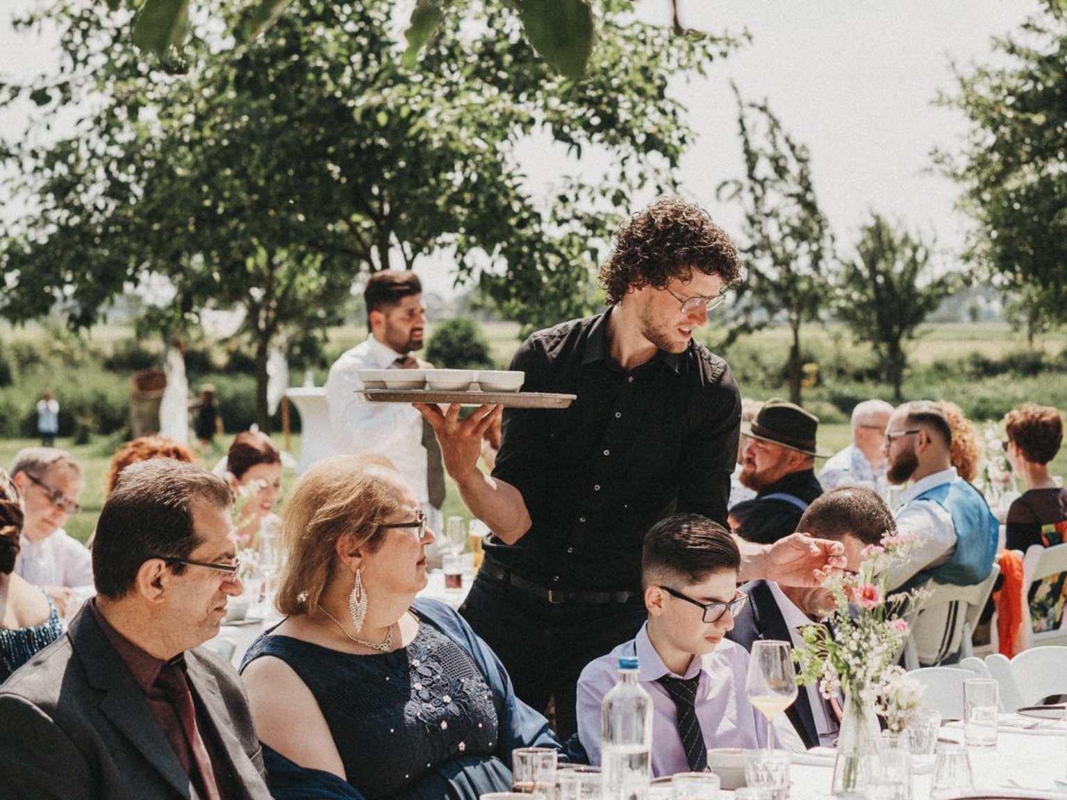 Een ober serveert het eten tijdens een bruiloft