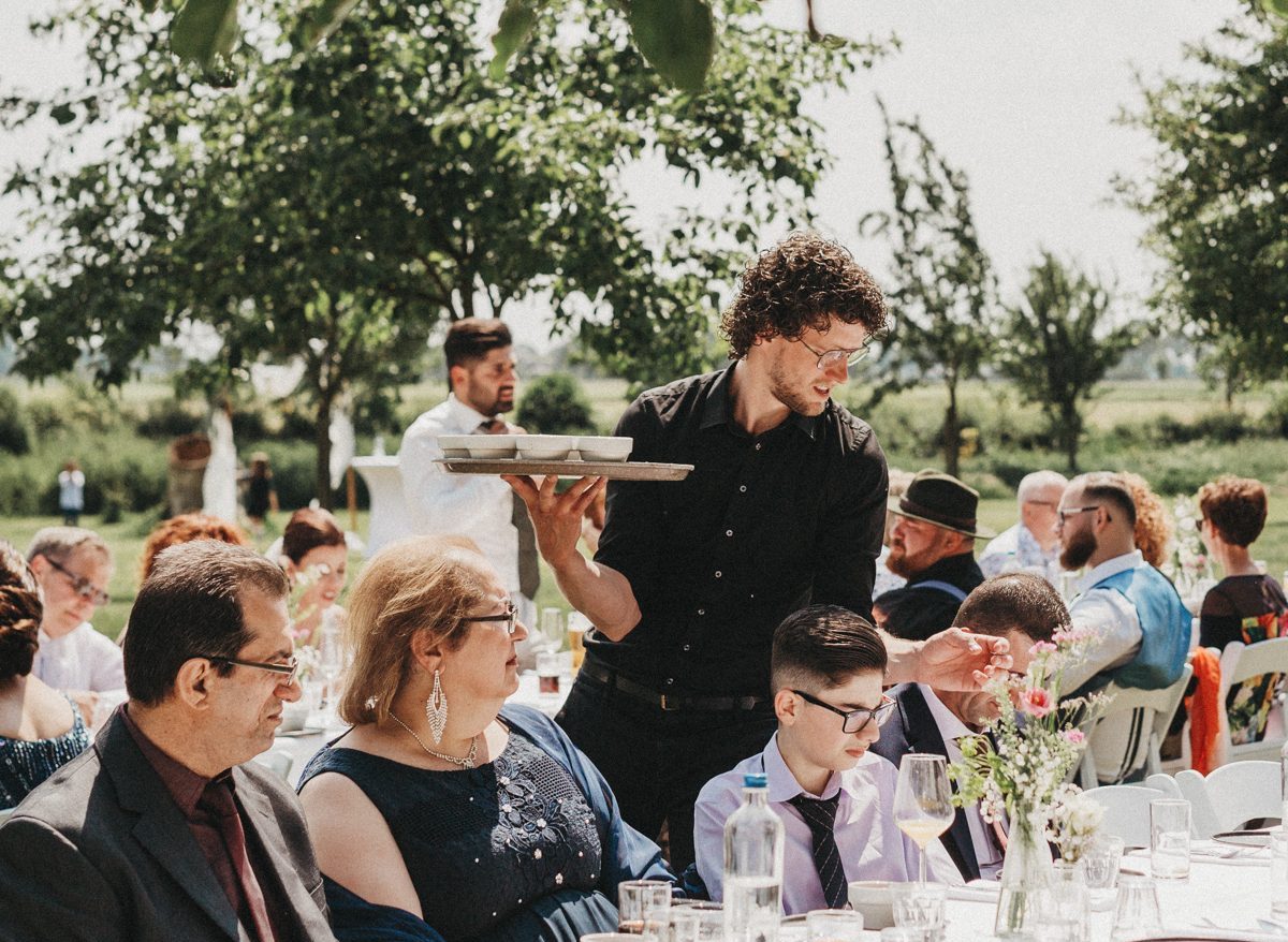 Een ober serveert het eten tijdens een bruiloft
